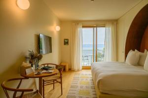 a hotel room with a bed and a table and a window at Auberge Port Gitana in Bellevue +64 photos