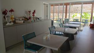 ein Esszimmer mit Tischen, Stühlen und Fenstern in der Unterkunft Pousada Village Premiere in Fernando de Noronha