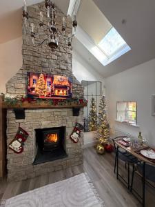 Aghade BridgeHolly Cottage Cozy Loft的客厅设有石制壁炉,配有圣诞树