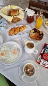 a table with a breakfast of eggs and croissants and coffee at Semiramis Guesthouse in Adamas +116 photos