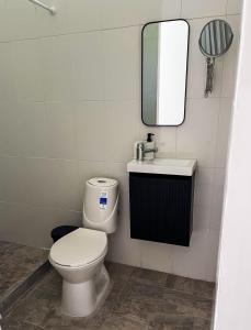 ein Badezimmer mit Toilette, Waschbecken und Spiegel in der Unterkunft Cabaña de campo la MariaCa in Utica + 15 Fotos