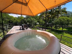 einen Whirlpool auf einer Terrasse mit einem Sonnenschirm in der Unterkunft Cabaña de campo la MariaCa in Utica