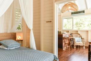 a bedroom with a bed and a table and a window at La poolhouse in Grand-Bourg +29 photos