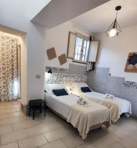 twee bedden in een kamer met witte muren bij Vico Si cu ro in Acireale