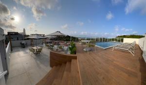 eine Dachterrasse mit einem Pool, Tischen und Stühlen in der Unterkunft Pousada Village Premiere in Fernando de Noronha
