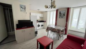 a living room with a red couch and a table at Les cascades in Le Mont-Dore