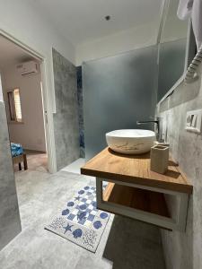 ein Badezimmer mit einem Waschbecken auf einem Holztisch in der Unterkunft Mimma house in Lampedusa