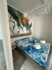 ein Bett in einem Zimmer mit einem Gemälde an der Wand in der Unterkunft Mimma house in Lampedusa