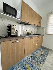 eine Küche mit Holzschränken und einer Mikrowelle in der Unterkunft Mimma house in Lampedusa + 33 Fotos