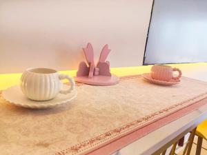 青岛青岛旺莎主题民宿的一张桌子上放着两个杯子和盘子 更多270张照片