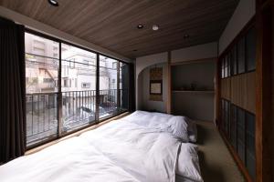 a bedroom with a large bed and a large window at New Open KIKUNOYA-sora- in Nagoya