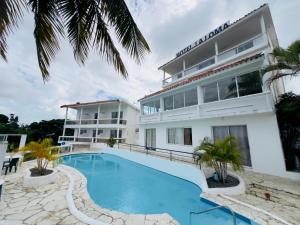 a hotel with a swimming pool in front of a building at Hotel La Loma in Miches +22 photos