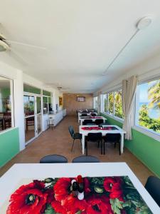 a room with tables and chairs with red flowers on the table at Hotel La Loma in Miches