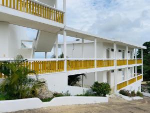 a white building with yellow balconies on it at Hotel La Loma in Miches