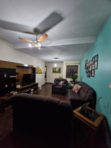 un soggiorno con un divano e un ventilatore a soffitto di Pousada de Muryan a São Gabriel