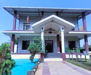 a house with a swimming pool in front of it at Divyesh Holiday Home in Nagaon