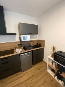 a small kitchen with a counter and a microwave at La Pomme de Pin - T1 Calme et Central - Meublé de Tourisme classé 2 étoiles in Saint-Jean-de-Monts +5 photos