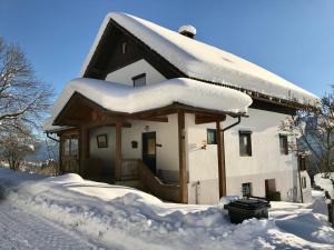 una casa cubierta de nieve con un montón de nieve en Haus Romsicht Karinthië, en Kerschdorf