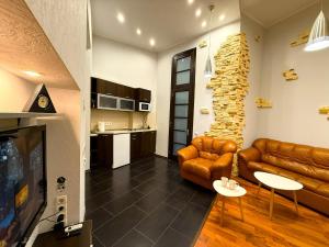 a living room with leather furniture and a tv at Kyiv Muse Apartment in Kyiv