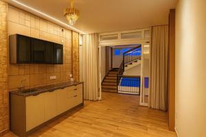 Una cocina con un fregadero y un televisor en la pared. en The Miste Munnar By D2V, en Munnar