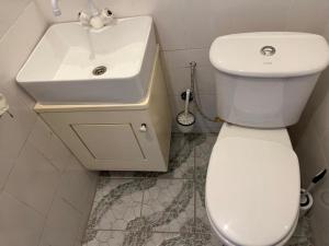 a bathroom with a white toilet and a sink at Chambre double in Mbour