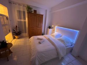 a bedroom with a white bed with a light on it at Chambre double in Mbour