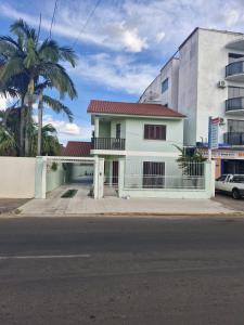 una casa bianca con un tetto rosso su una strada di Pousada de Muryan a São Gabriel