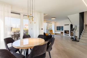 a dining room and living room with a table and chairs at Hiša Urma in Celje