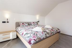 a bedroom with a bed and a dresser with towels on it at Hiša Urma in Celje