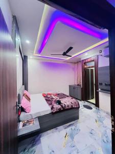 AyodhyaHotel Kaushalya的一间卧室，里面有一张床，天花板上亮着紫色的灯。 更多29张照片