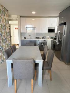 a kitchen with a table and chairs in a kitchen at Flat 4 Block 12 Bellamare in Port Elizabeth