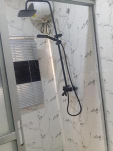 a shower in a bathroom with a light on a wall at GA guest House in Ibadan