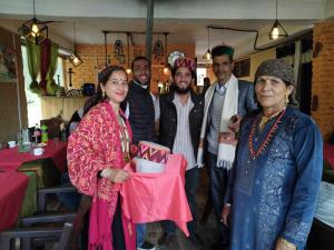 a group of people posing for a picture in a restaurant at Shiva Valley Riverside in Jibhi +73 photos