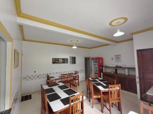 a dining room with tables and chairs and a kitchen at Hotel Val-de-Cans Aeroporto in Belém +30 photos