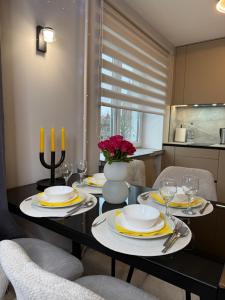 a dining room with a table with plates and candles at Near Passage in Jelgava +40 photos