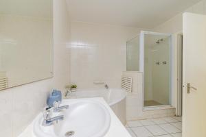 a white bathroom with a sink and a bath tub at Sea-Renity 10 in Umdloti