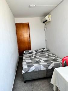 una piccola camera con un letto con una coperta a scacchi di Cartagena Hostel a Cartagena de Indias