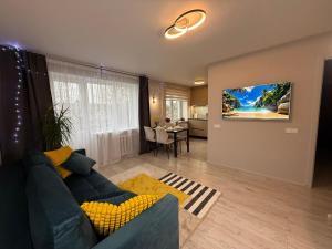 a living room with a blue couch and a tv on a wall at Near Passage in Jelgava