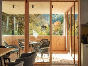 una stanza con porte in vetro e tavolo e sedie di Kreithner luxury apartments a Vandoies