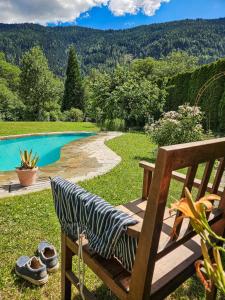 una panchina di legno seduta sull'erba accanto a una piscina di Kreithner luxury apartments a Vandoies