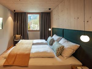 una camera da letto con un letto grande con testiera verde di Kreithner luxury apartments a Vandoies Altre 28 foto