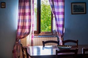 蒙特法尔科吉罗拉莫教主酒店的餐桌和带窗帘的窗户