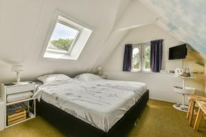 Un dormitorio con una cama grande y una ventana. en B&B De Duinhoek, en Beverwijk
