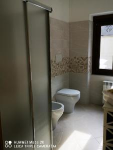 达尔福B & B La Mela的带马桶和玻璃淋浴门的浴室