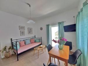 un soggiorno con un letto e un tavolo di Dimitra's Pretty Apartment 4 klm away from Chora ad Andro