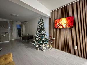 a christmas tree in a living room with a fireplace at Gold House in Bucharest