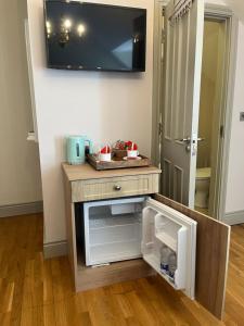 a small cabinet with a tv on a wall at clover cottage in Kinsale