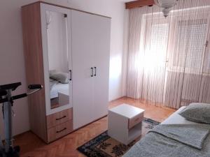 1 dormitorio con espejo grande y cama en Apartman Čeliković, en Bosanski Šamac