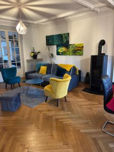 a living room with a blue couch and a yellow chair at Séjour entre ville et montagnes Appartement 90 m2 in Thann