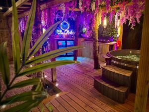 a jacuzzi tub in a room with purple lights at The Secret Garden Glamping Lancashire in Skelmersdale